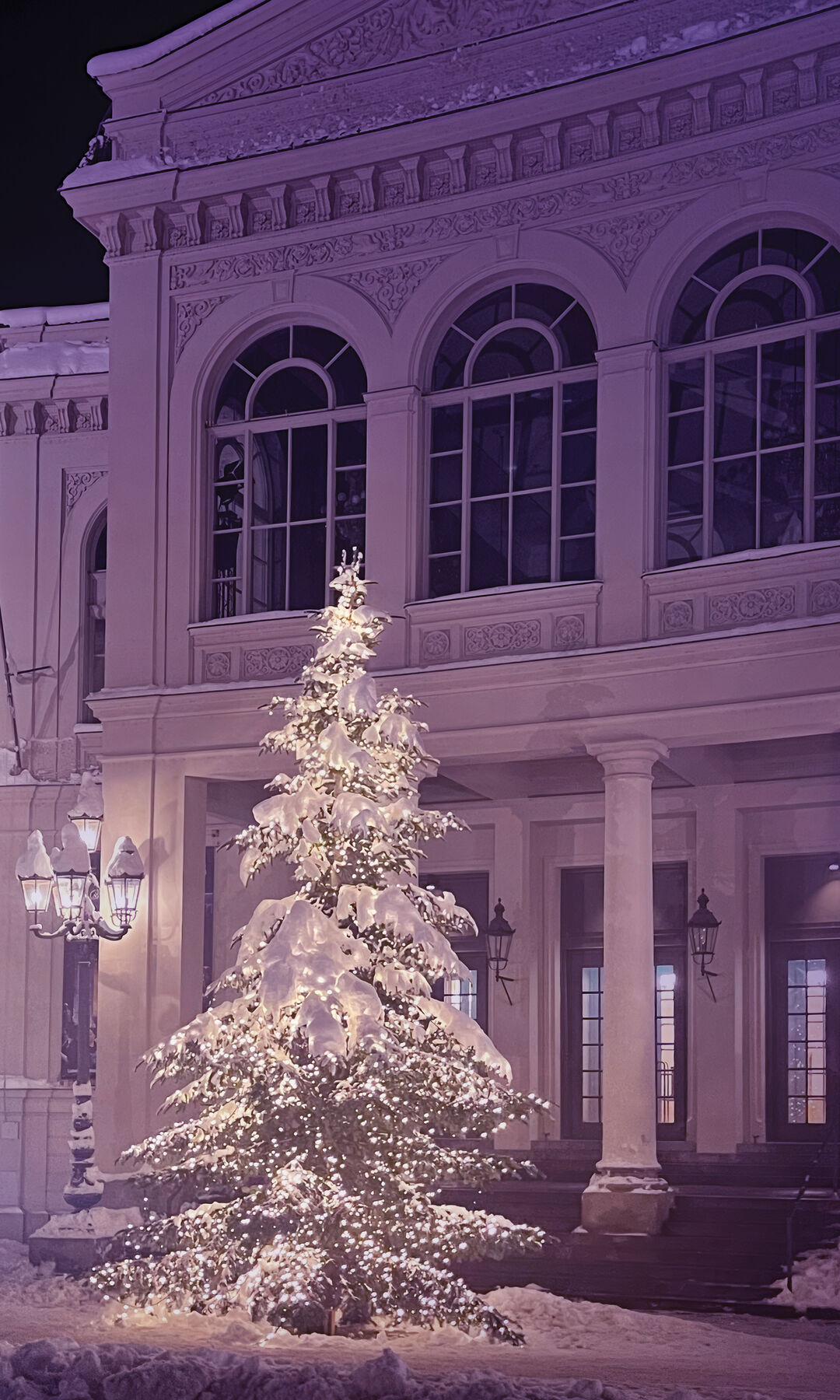 Ein verschneiter Weihnachtsbaum steht vor dem Gärtnerplatztheater.