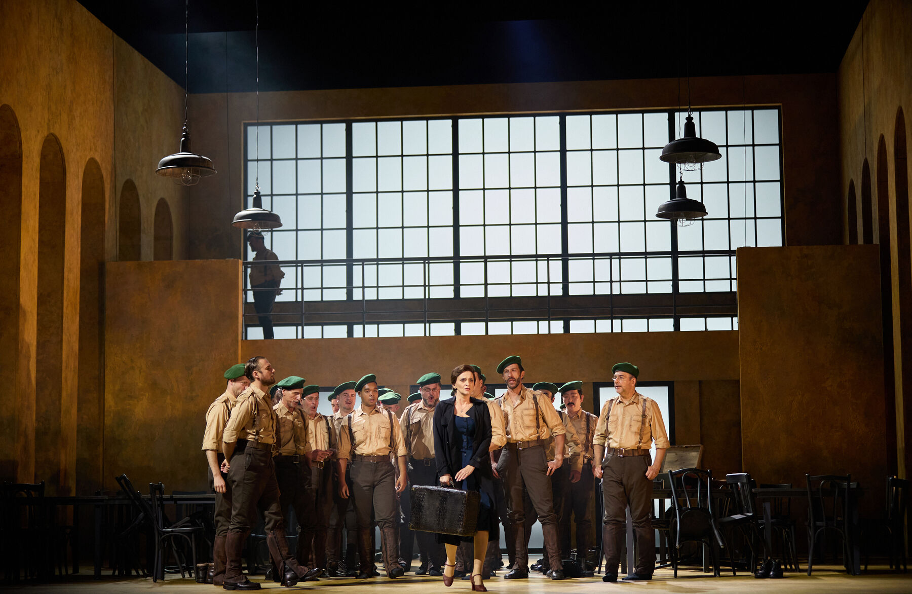 A woman with a suitcase is surrounded by a group of men in uniform.