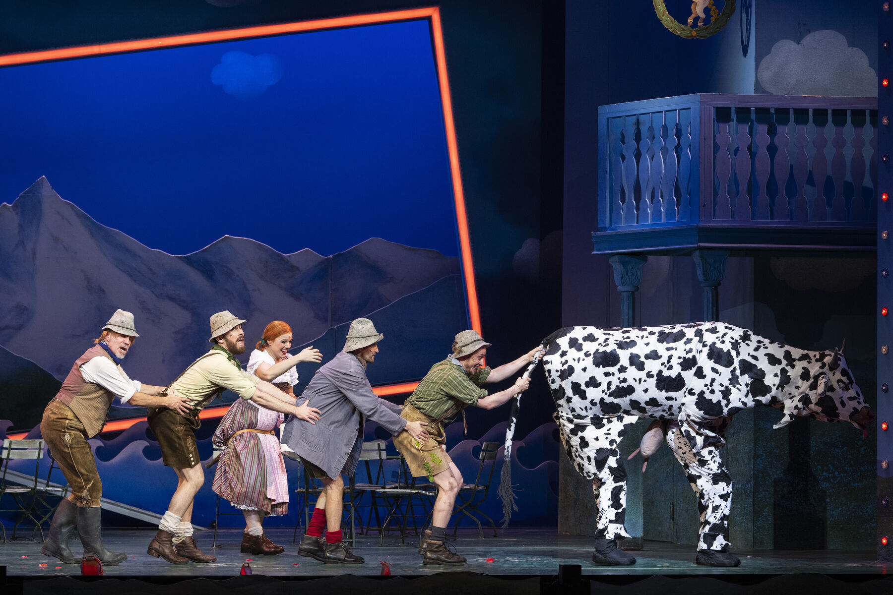 Fünf Darstellerinnen stehen hintereinander auf der Bühne. Vor ihnen ist eine Kuh zu sehen.