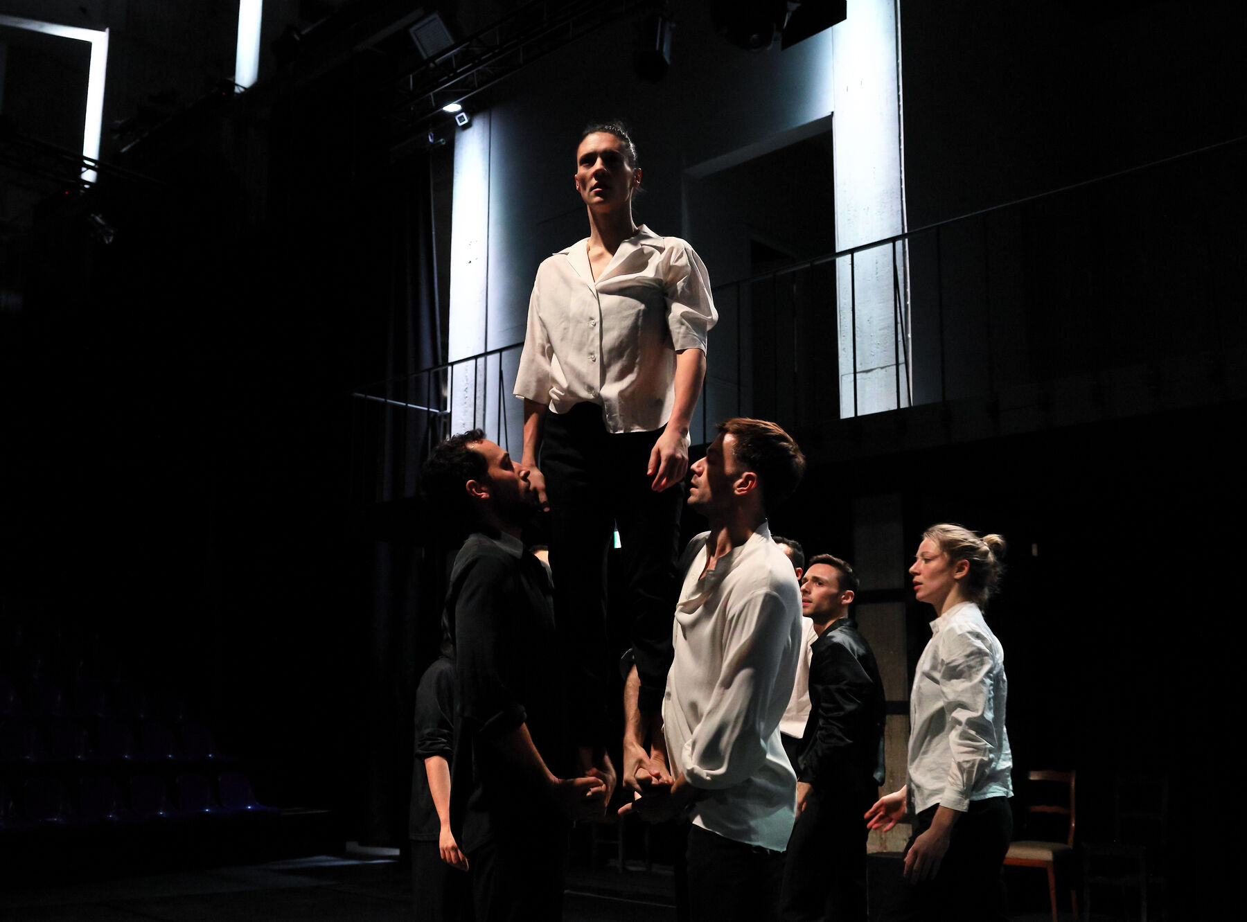 Dancers can be seen in a dark room.