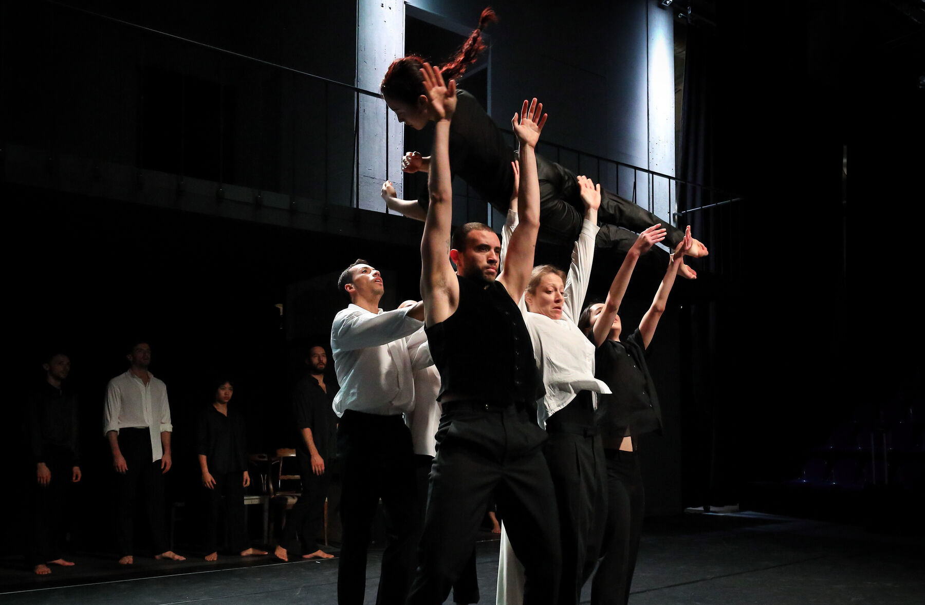 Dancers, dressed in black and white, can be seen.