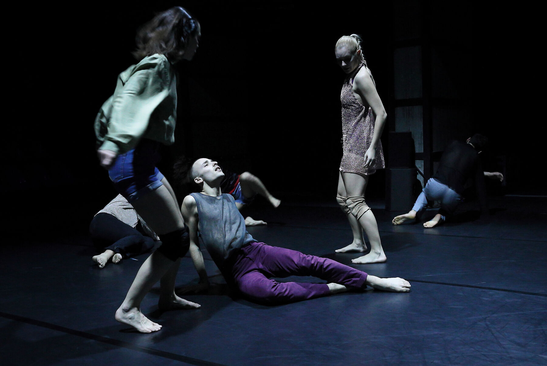 People are dancing in a dark room.