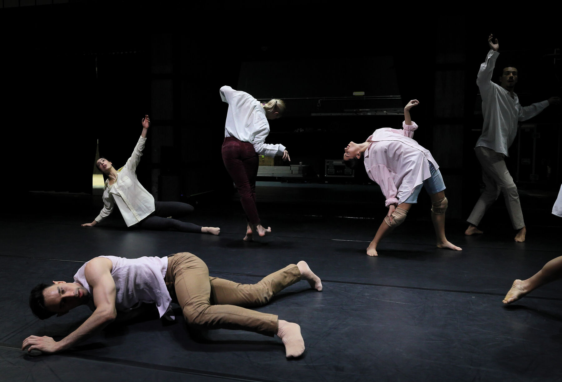 Dancers can be seen in a dark room.