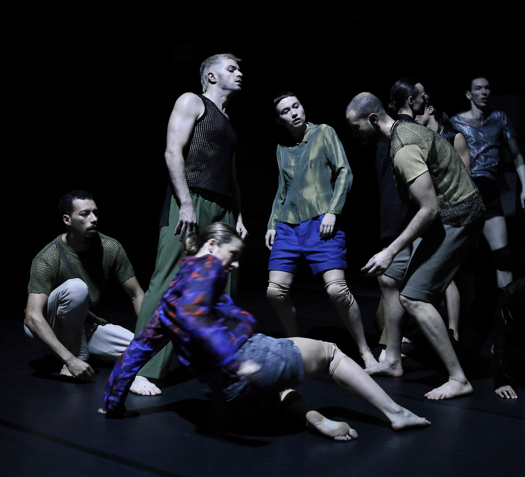 Dancers in a dark room can be seen.