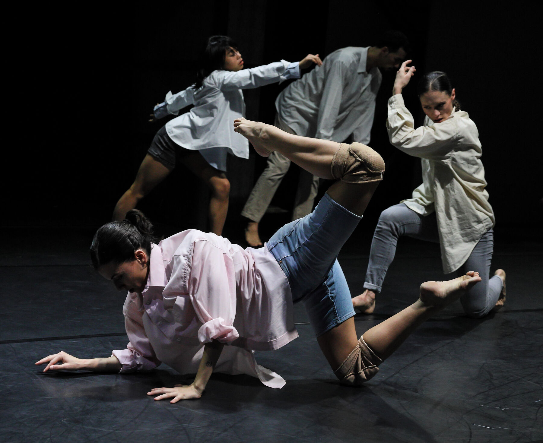 Dancers can be seen in a dark room.