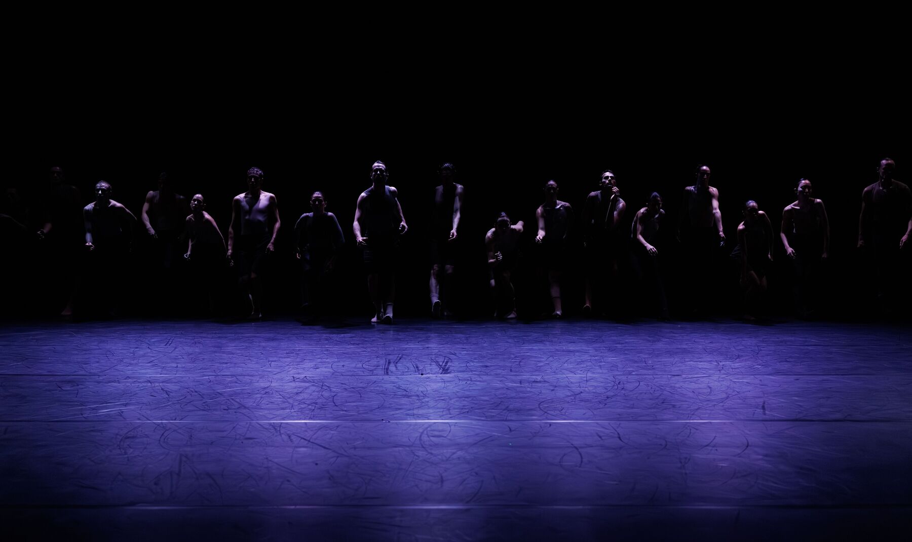 Dancers move in one line. It seems as if they are moving towards the front. 