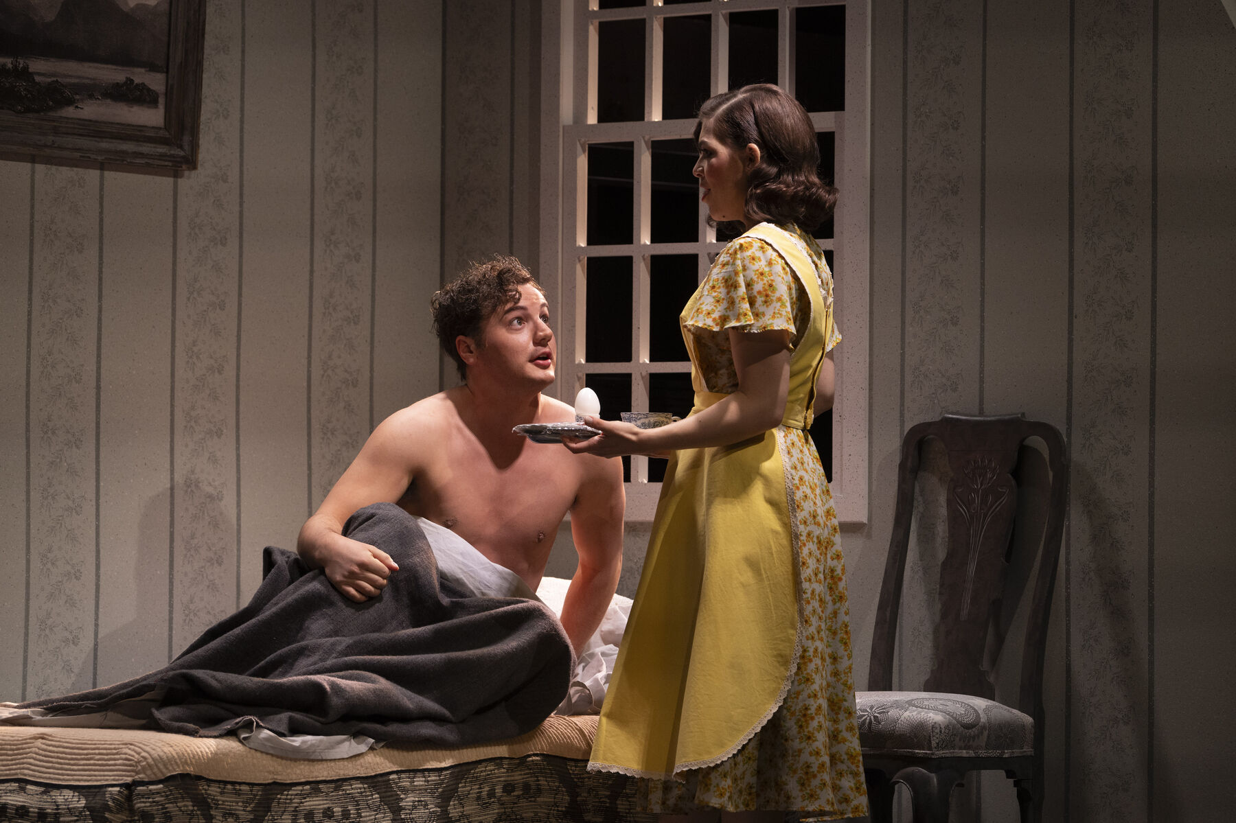 Bob sits in his bed with his shirt off. Laeticia brings him a cup of tea and an egg. 