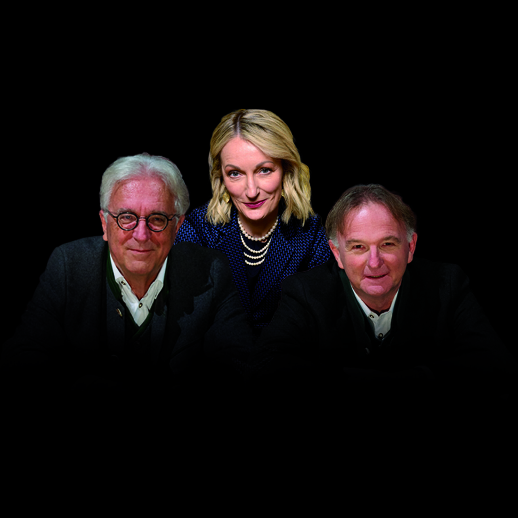 Gerd Anthoff, Monika Gruber, Michael Lerchenberg stehen vor einem dunklen Hintergrund. 