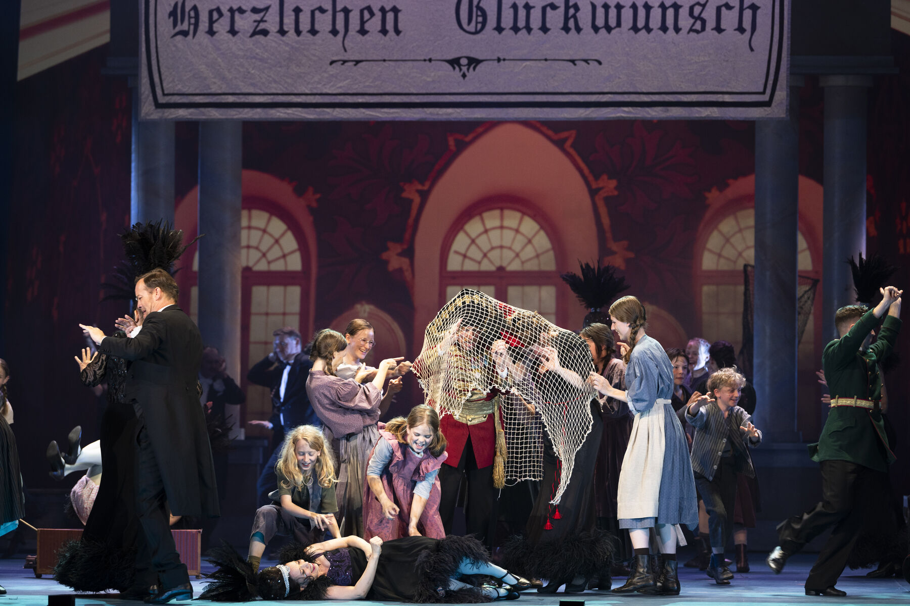 Einige Kinder in ärmlicher Kleidung fangen adelig aussehende Erwachsene unter einem Netz.