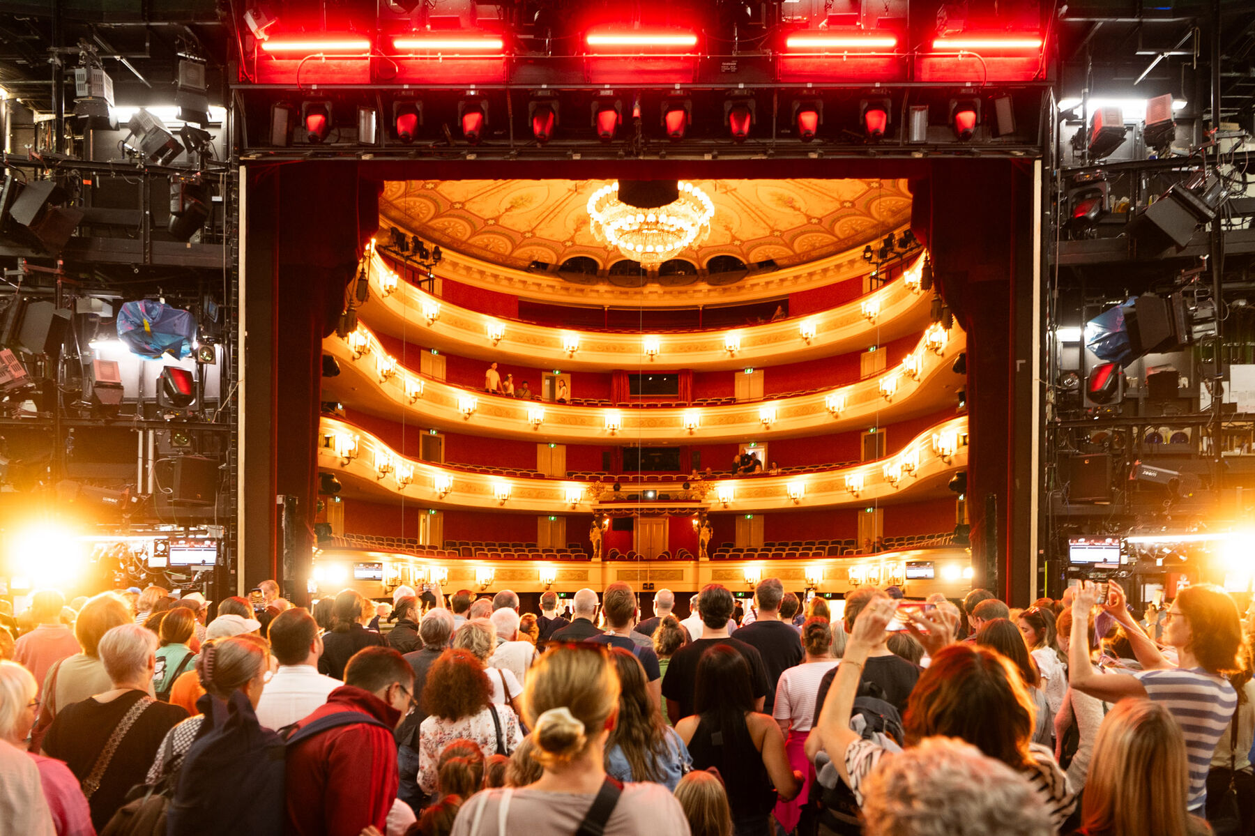 Besucherinnen und Besucher stehen auf der Bühne des Gärtnerplatztheaters und schauen in den Zuschauerraum