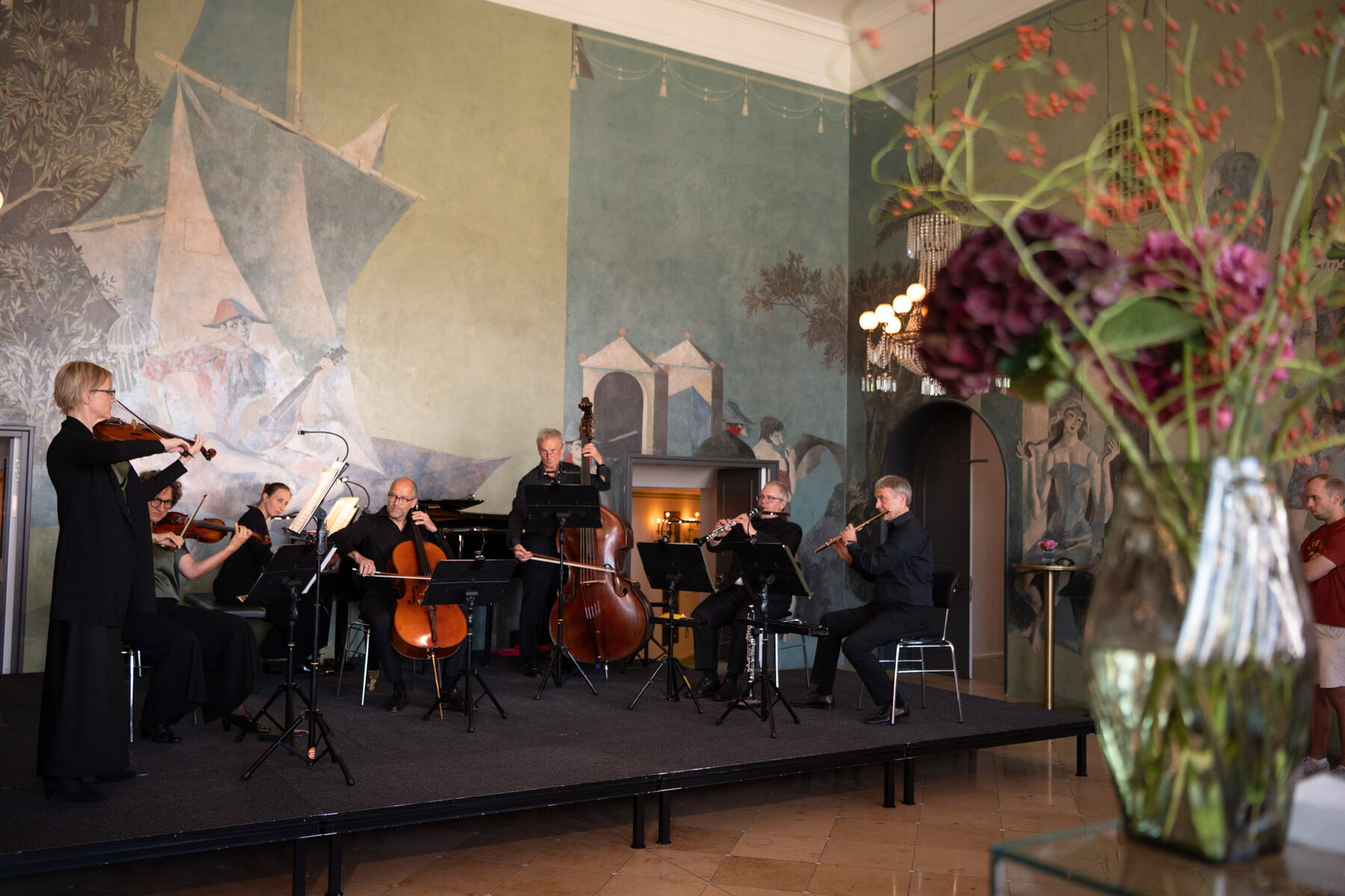 Drei Streicher, zwei Holzbläser und eine Pianistin spielen auf einer Bühne im Pausenfoyer