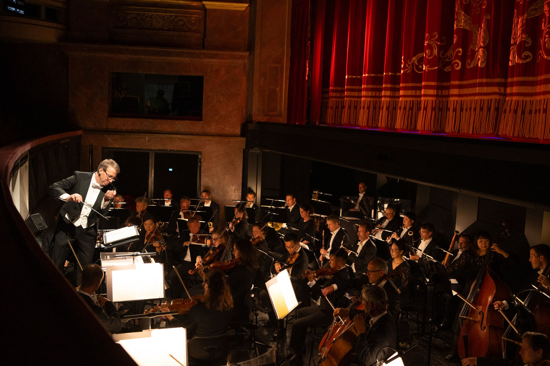  Michael Brandstätter steht im Orchestergraben und dirigiert das Orchester  