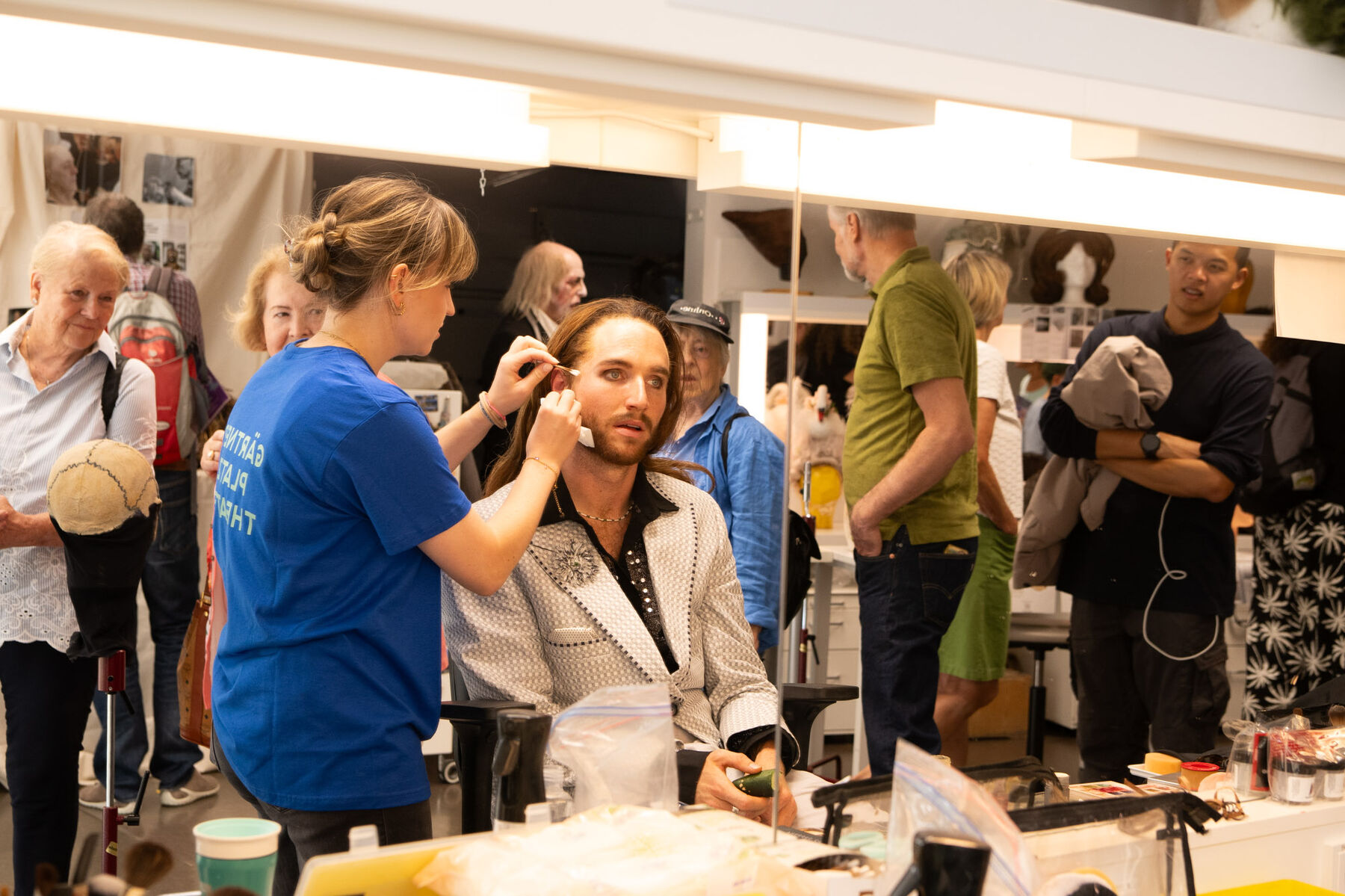  Alexander Paul Findewirth sitzt vor dem Spiegel und wird von einer Mitarbeiterin der Maske geschminkt